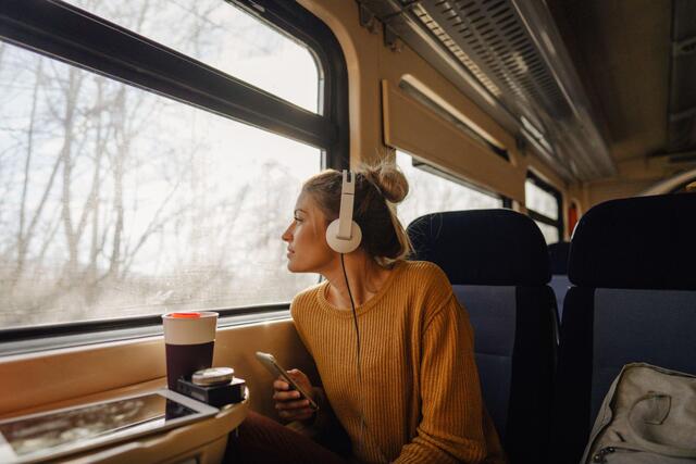 Useful electronics and gadgets for modern women travelers, including a smartphone and noise-canceling headphones.